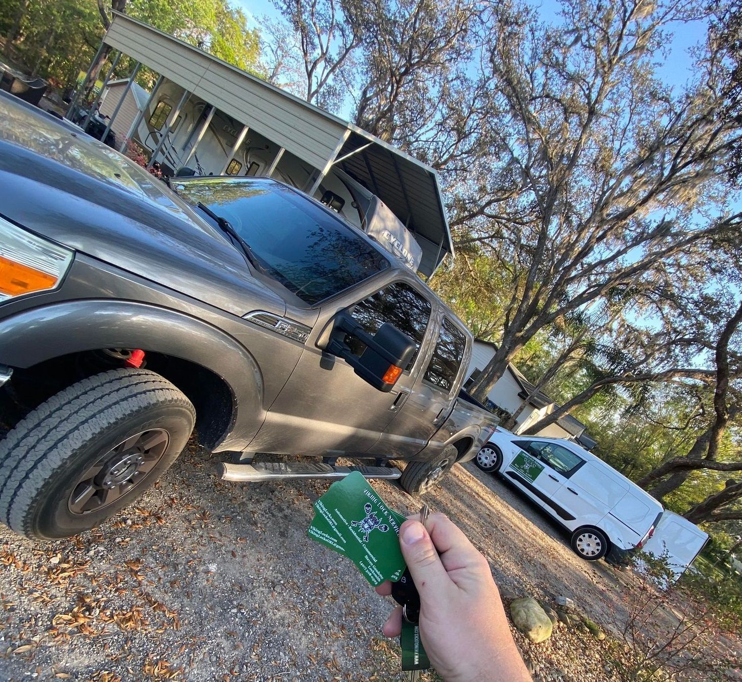 A person is holding a remote control in front of a truck.