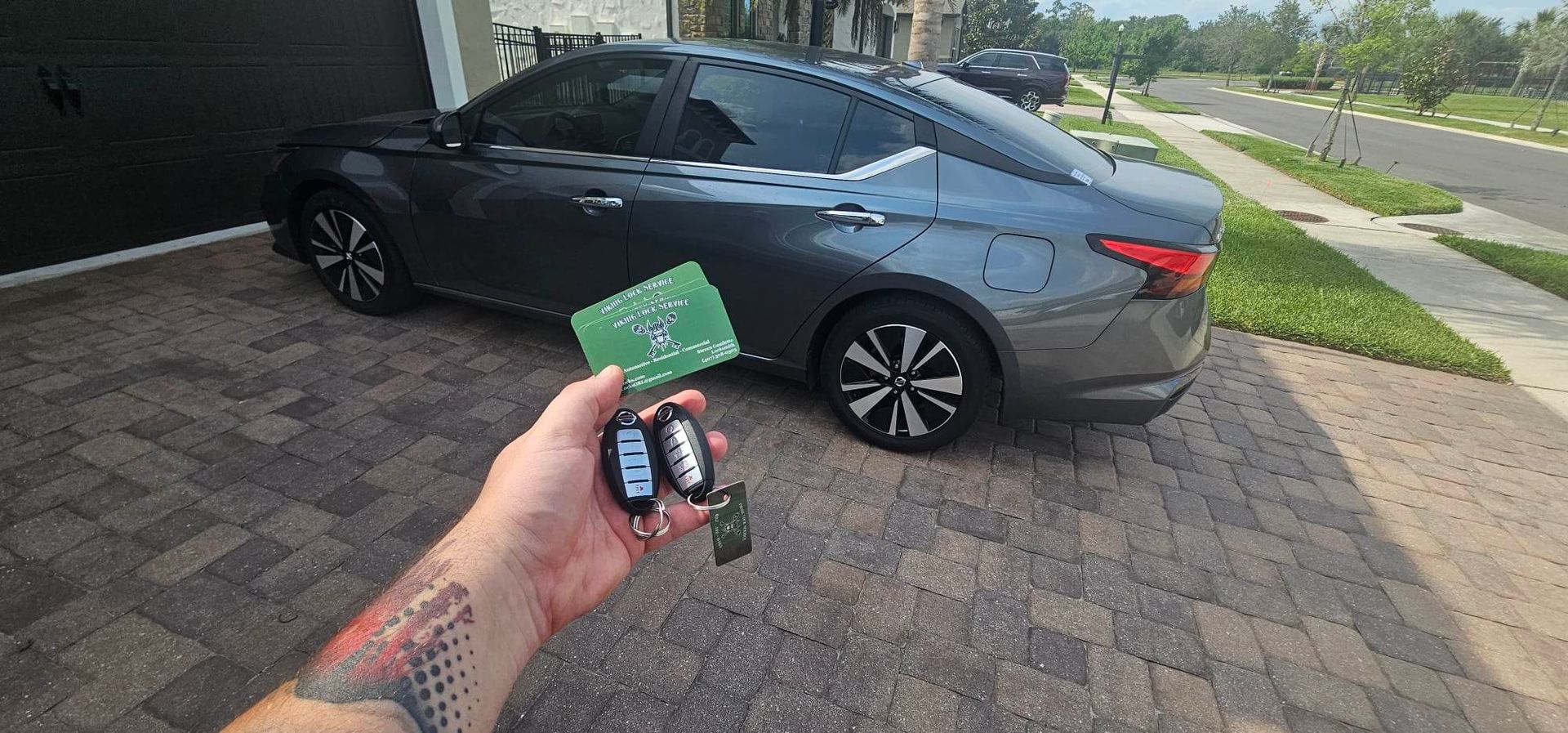A person is holding a remote control in front of a car.