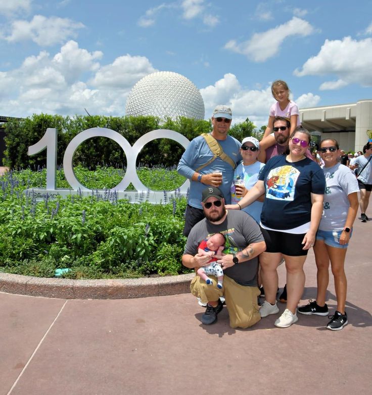 A group of people standing in front of a sign that says 100