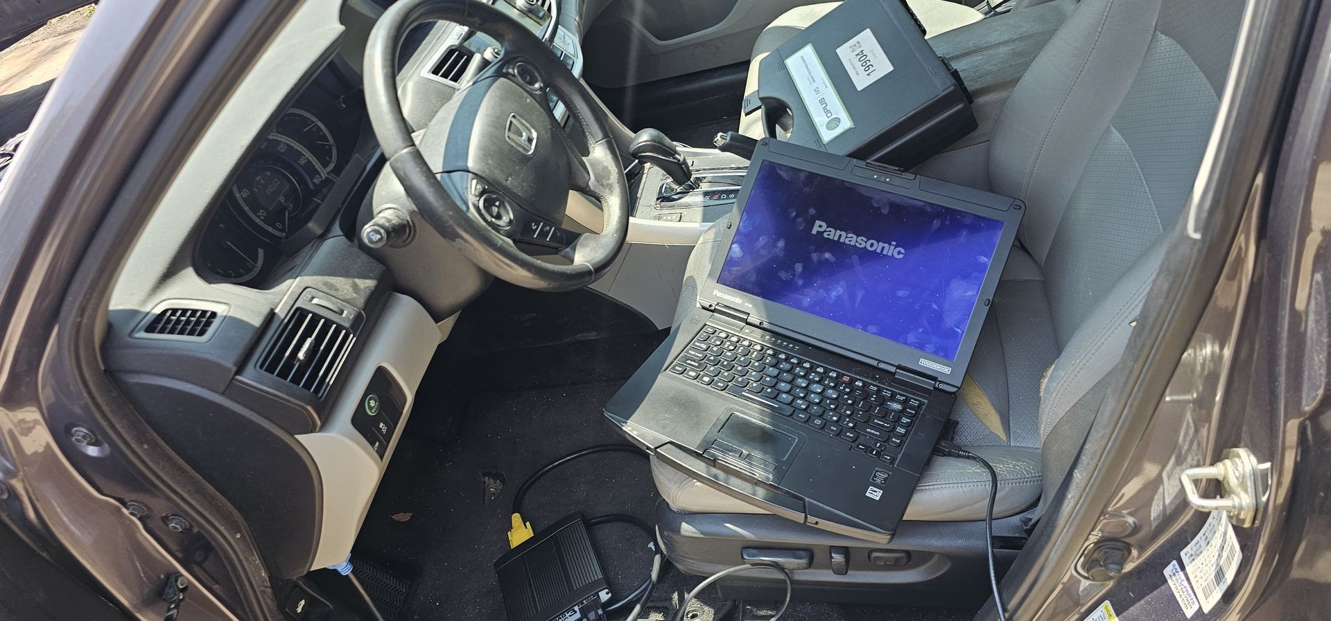 Two laptops are sitting in the back seat of a car.