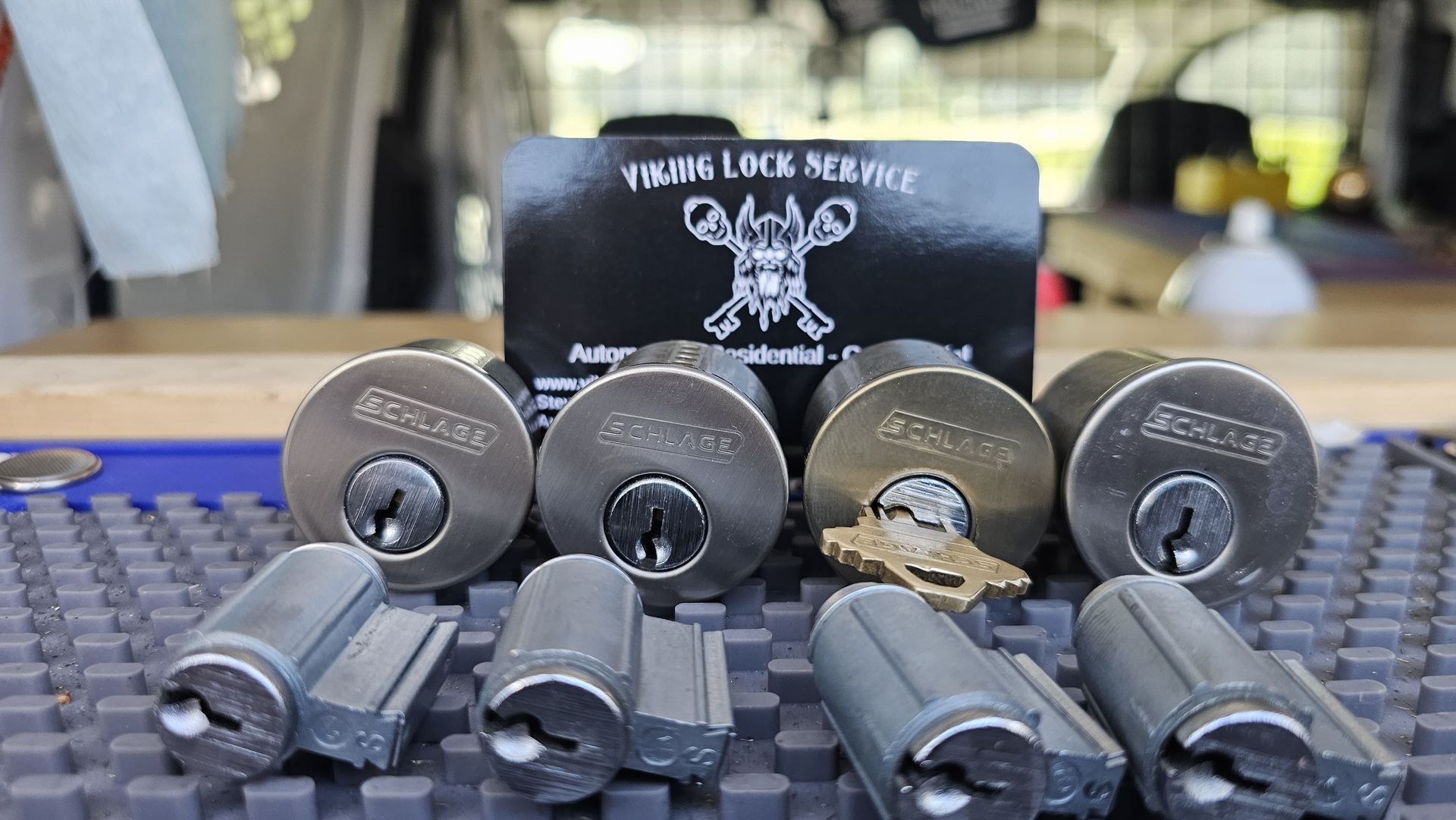 A bunch of locks are sitting on a table next to a card.