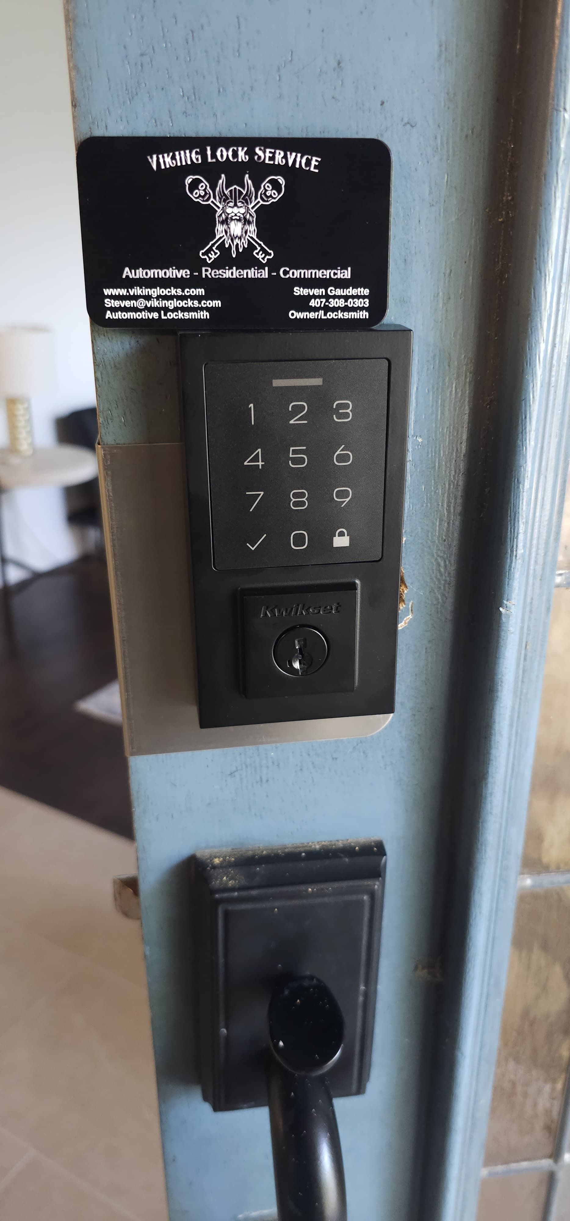 A door with a keypad and a sticker on it.