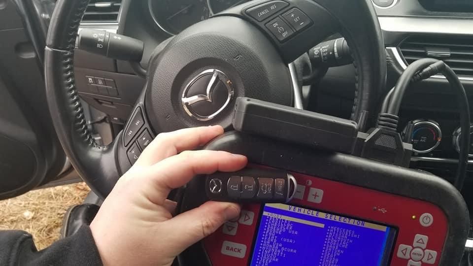 A person is using a diagnostic device in a car.