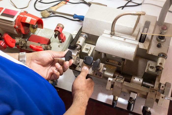 A man is using a machine to make a key.
