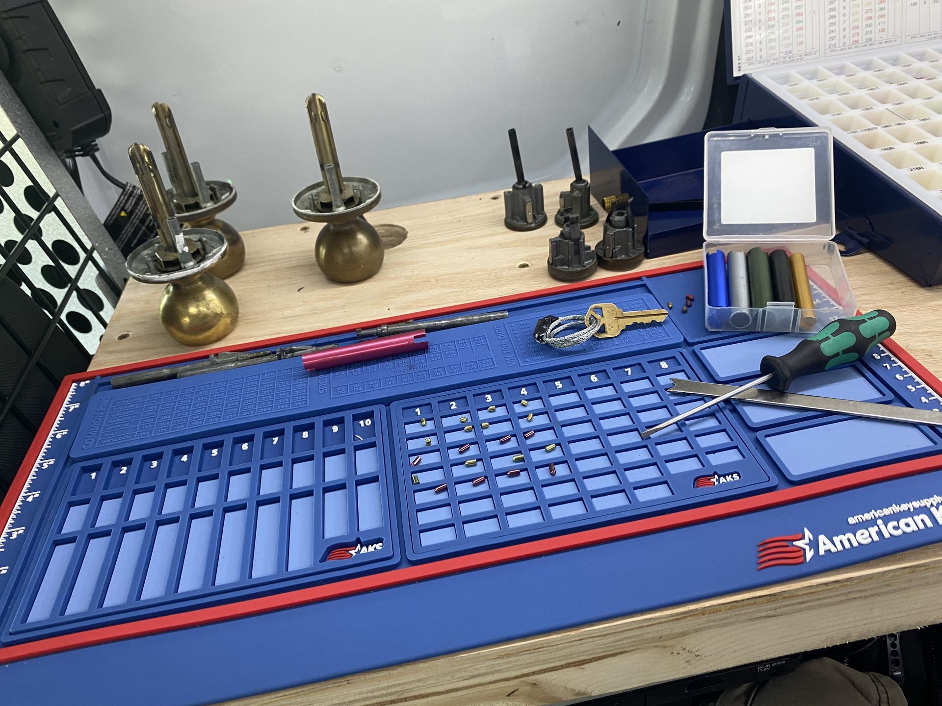 A blue and red mat with tools on it is on a wooden table.