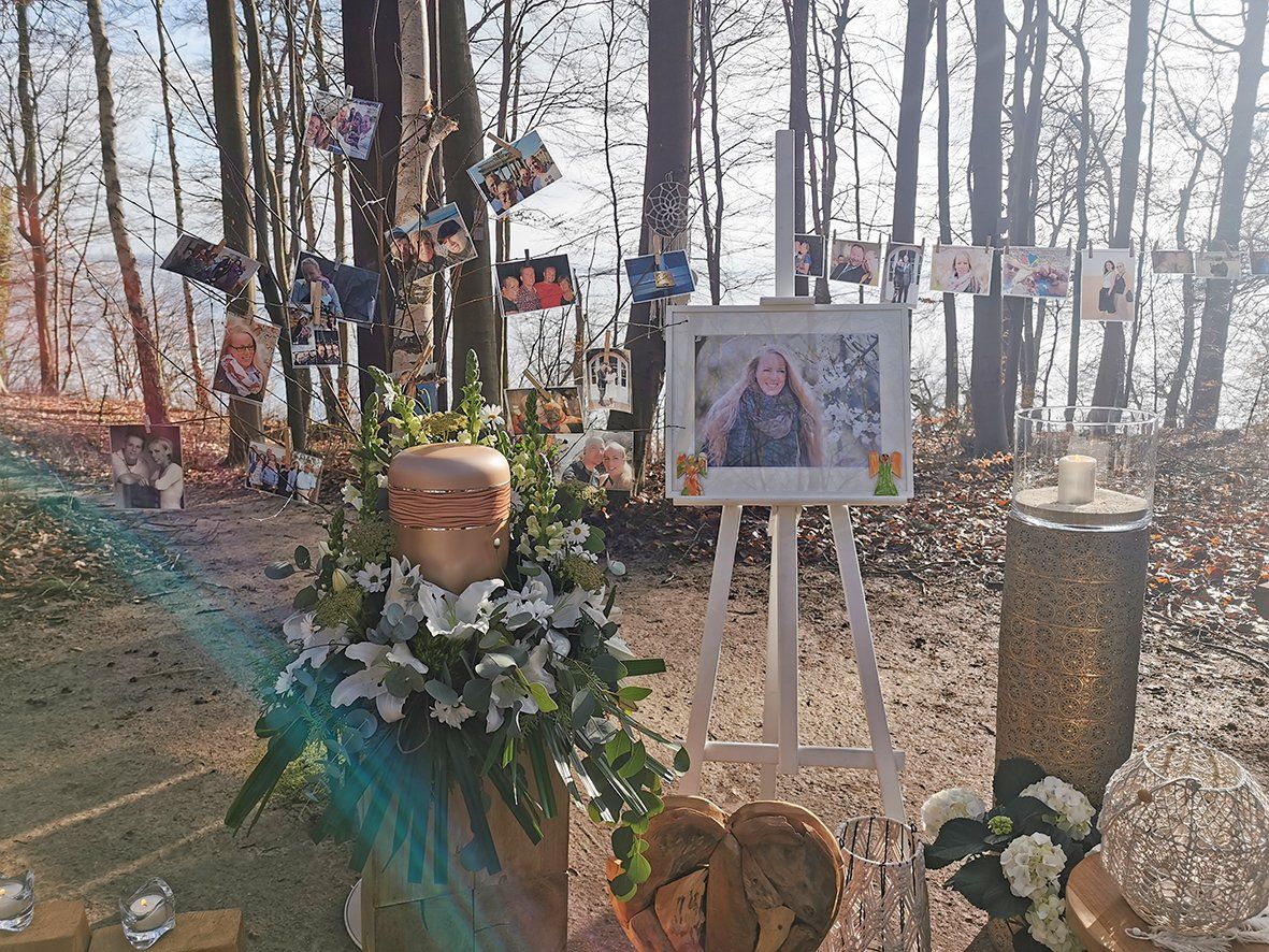Auf einer Staffelei im Wald steht das Bild einer Frau.