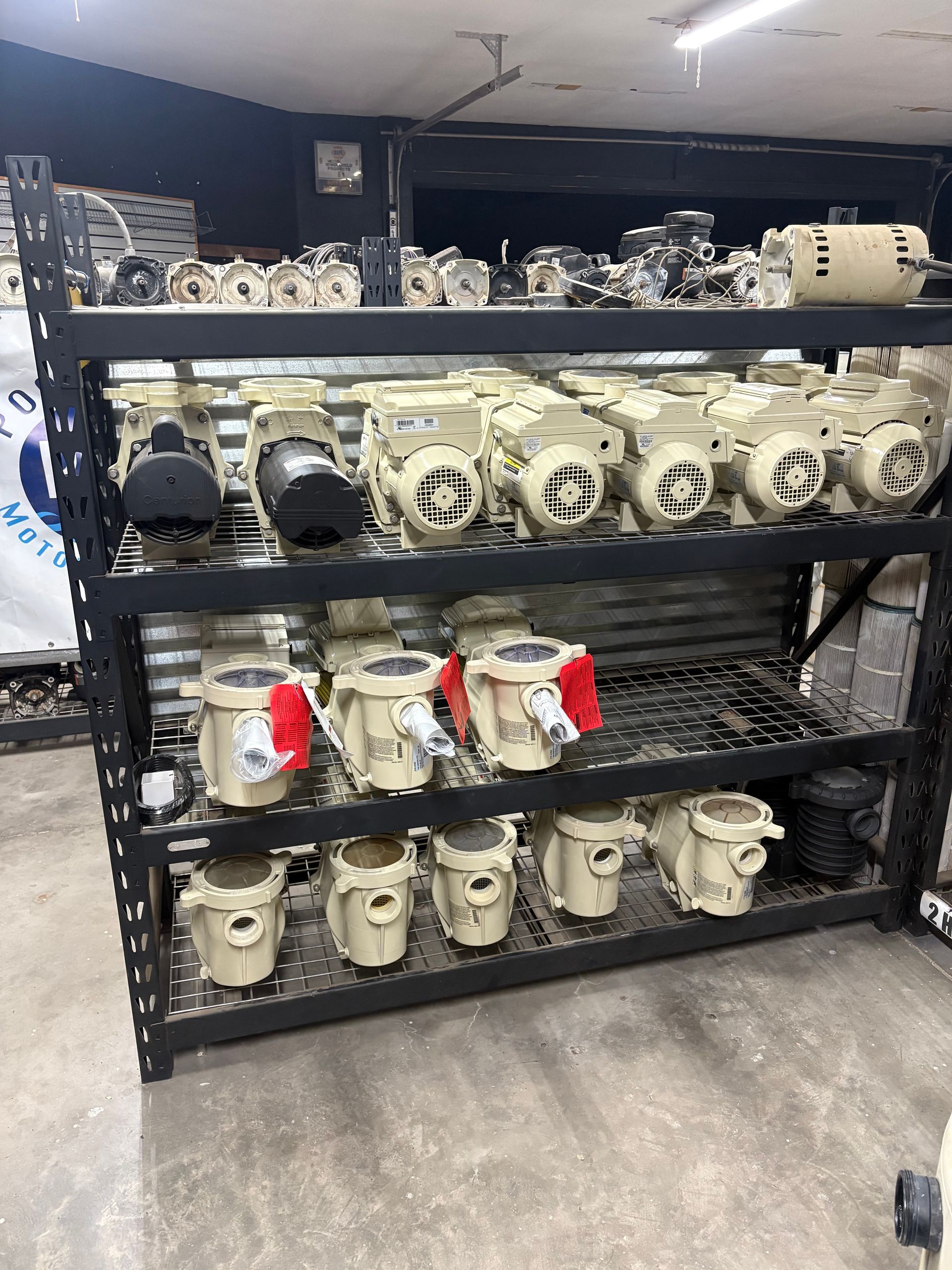 The Pool Boy Motors repair shop with shelves filled with pump motors and filters.