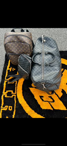 Two bags are sitting on top of a yellow and black rug.