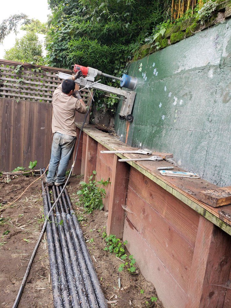 A man is using a machine to cut a hole in a wall.