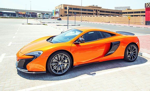 An orange sports car is parked in a parking lot.