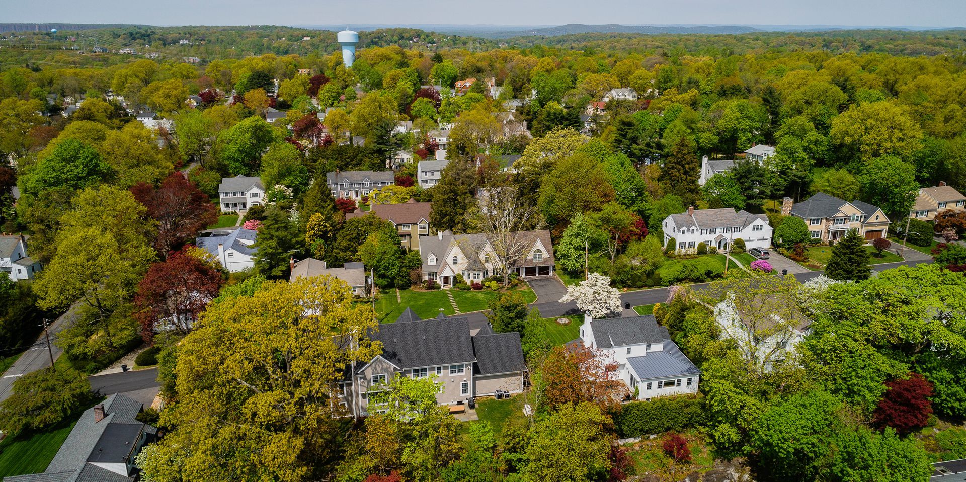 An aerial view of a residential area filled with lots of trees and houses. An aerial view of a residential area filled with lots of trees and houses.