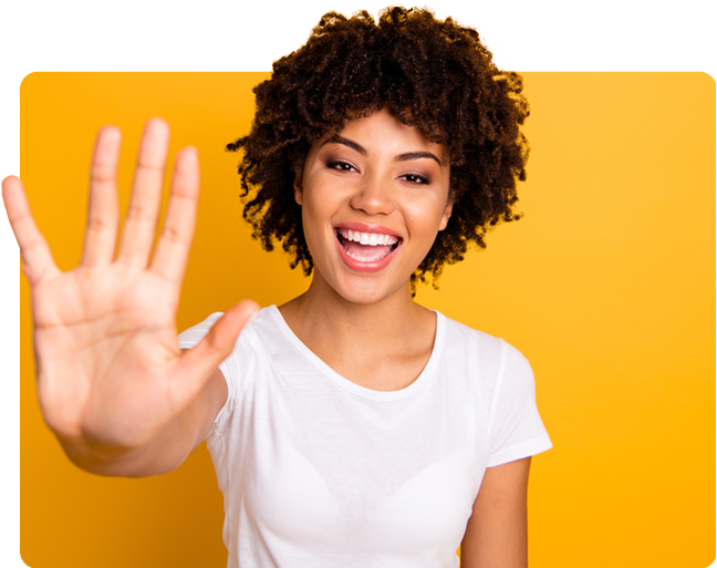 Smiling person in a white shirt holding up an open hand against a yellow background