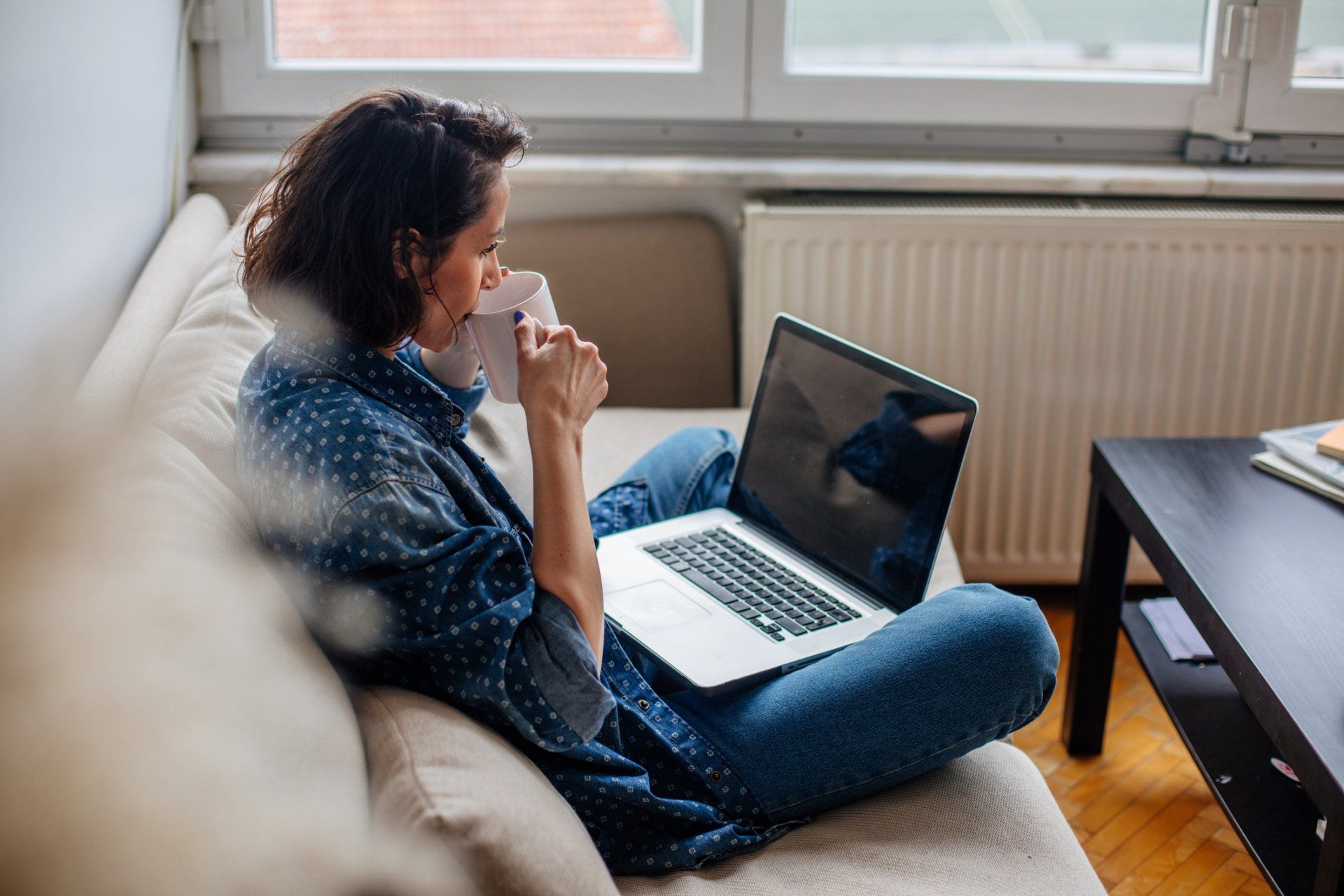 Woman Sipping Coffee while Surfing the Web — Seguin, TX — Guadalupe Valley Family Violence Shelter, Inc.