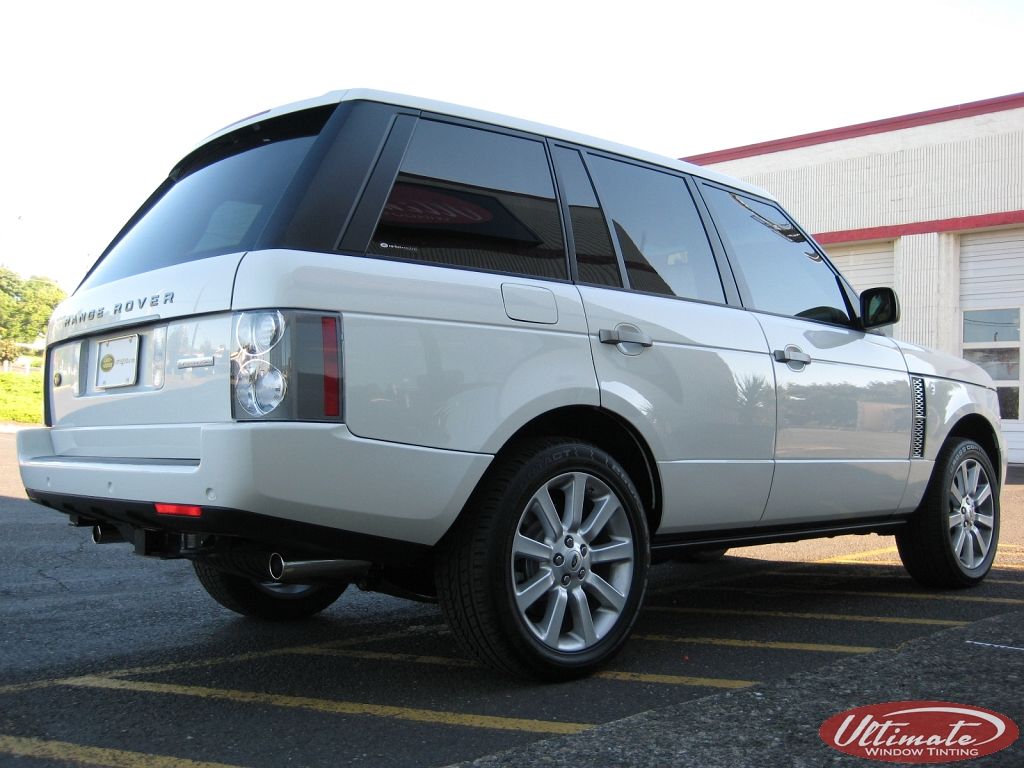 Silver SUV parked outdoors at a dealership, rear three-quarter view, with tinted windows and alloy wheels