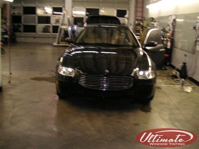 Black car in a garage with both front doors open.