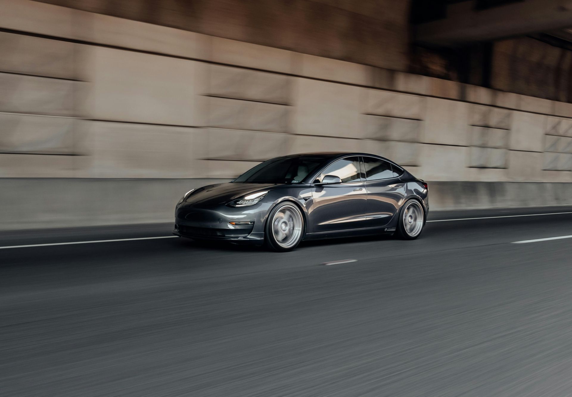 Black sports car driving through a tunnel at speed