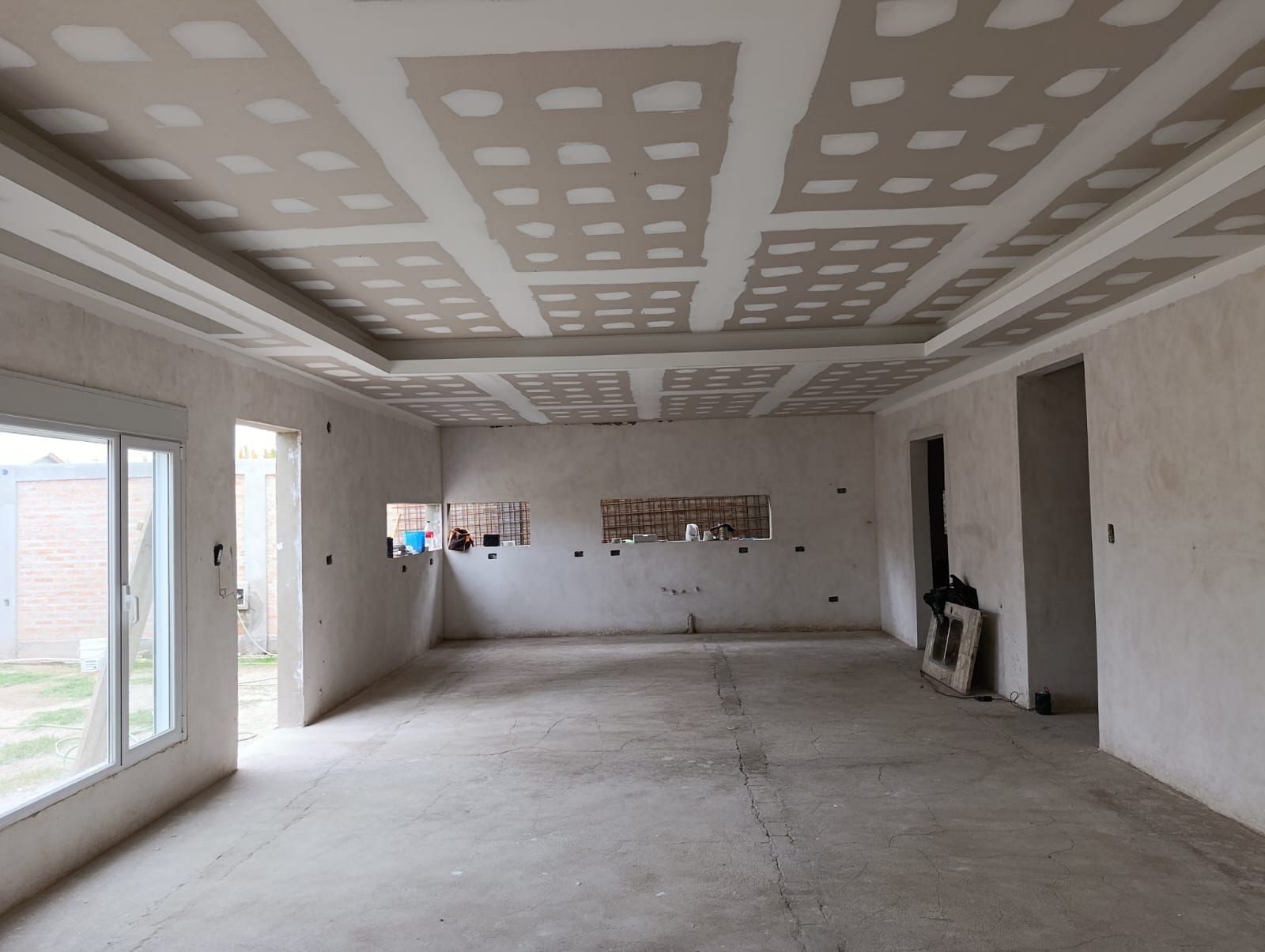 Habitación vacía sin terminar, con paredes de pladur, parches de yeso en el techo