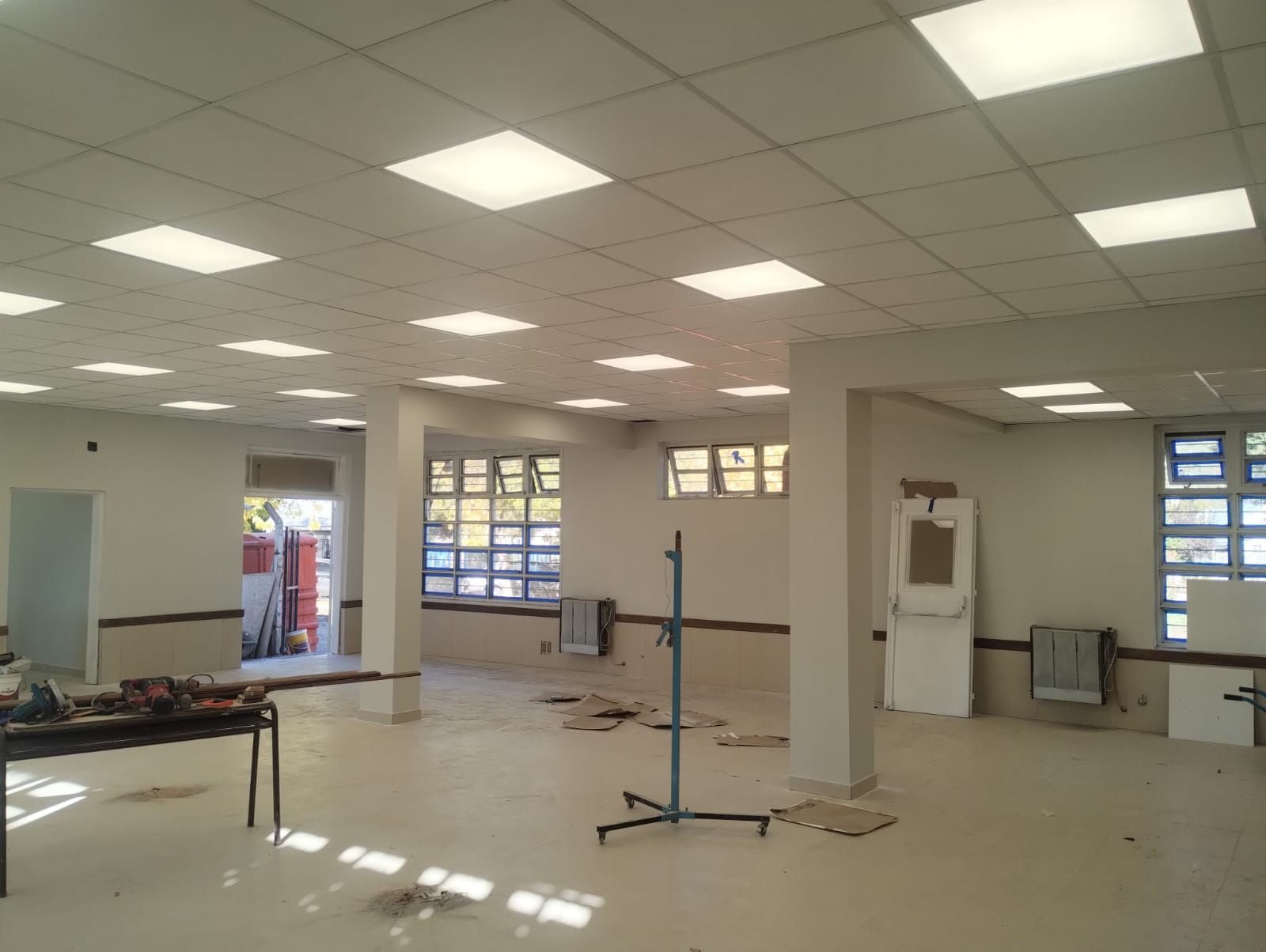 Habitación vacía sin terminar, con suelo de baldosas, luces en el techo