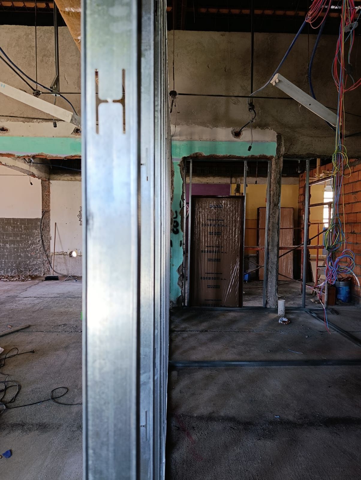 Interior abandonado con columnas metálicas, suelos de hormigón