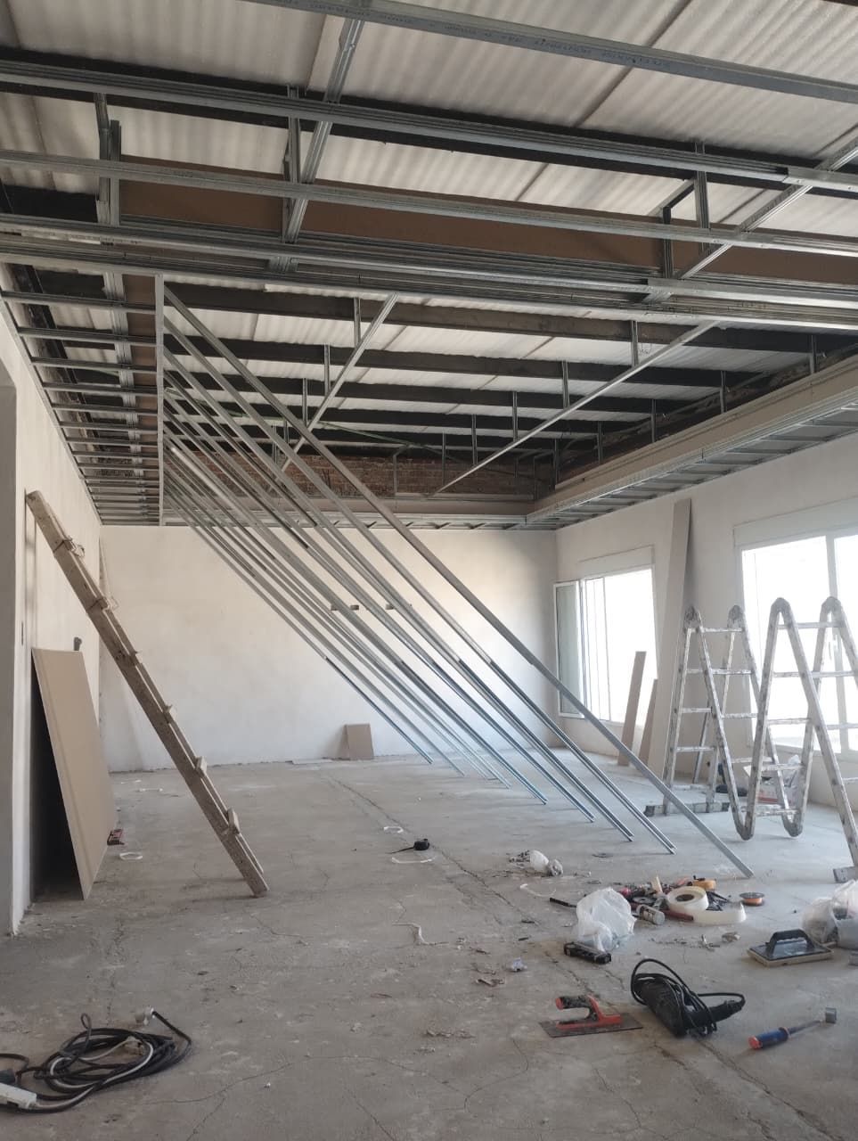 Interior de una habitación en construcción con estructura metálica en el techo