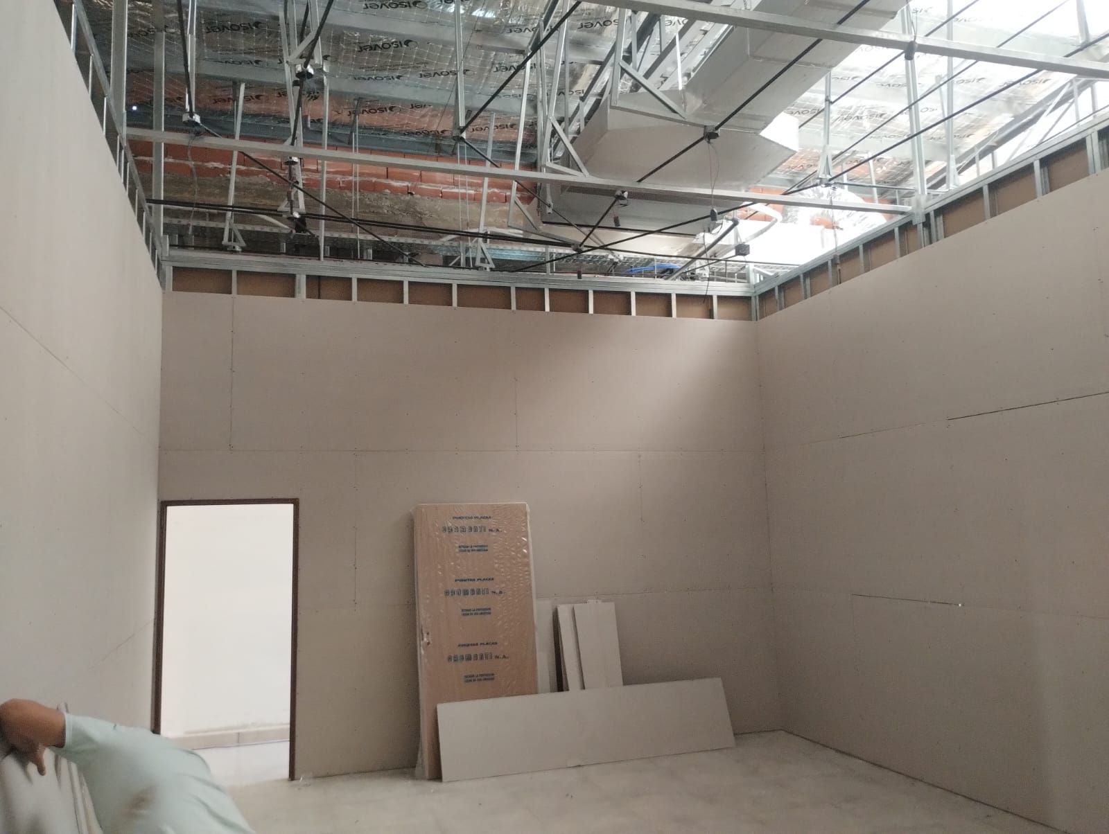 Habitación vacía en construcción con paredes de yeso sin terminar