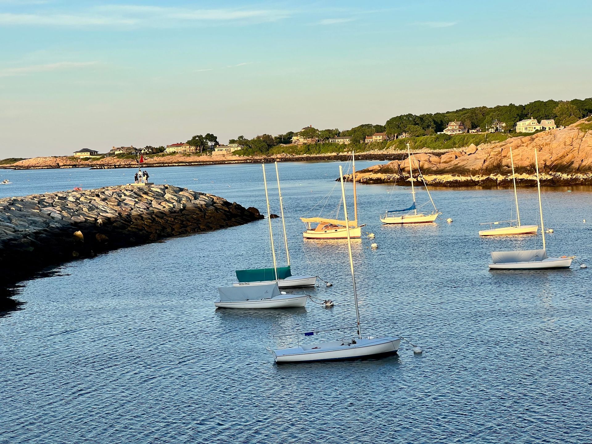 A group of sailboats are floating on top of a body of water