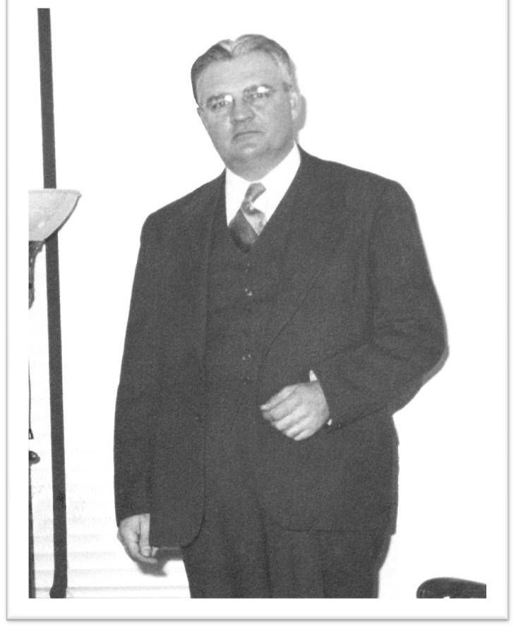 A black and white photo of a man in a suit and tie