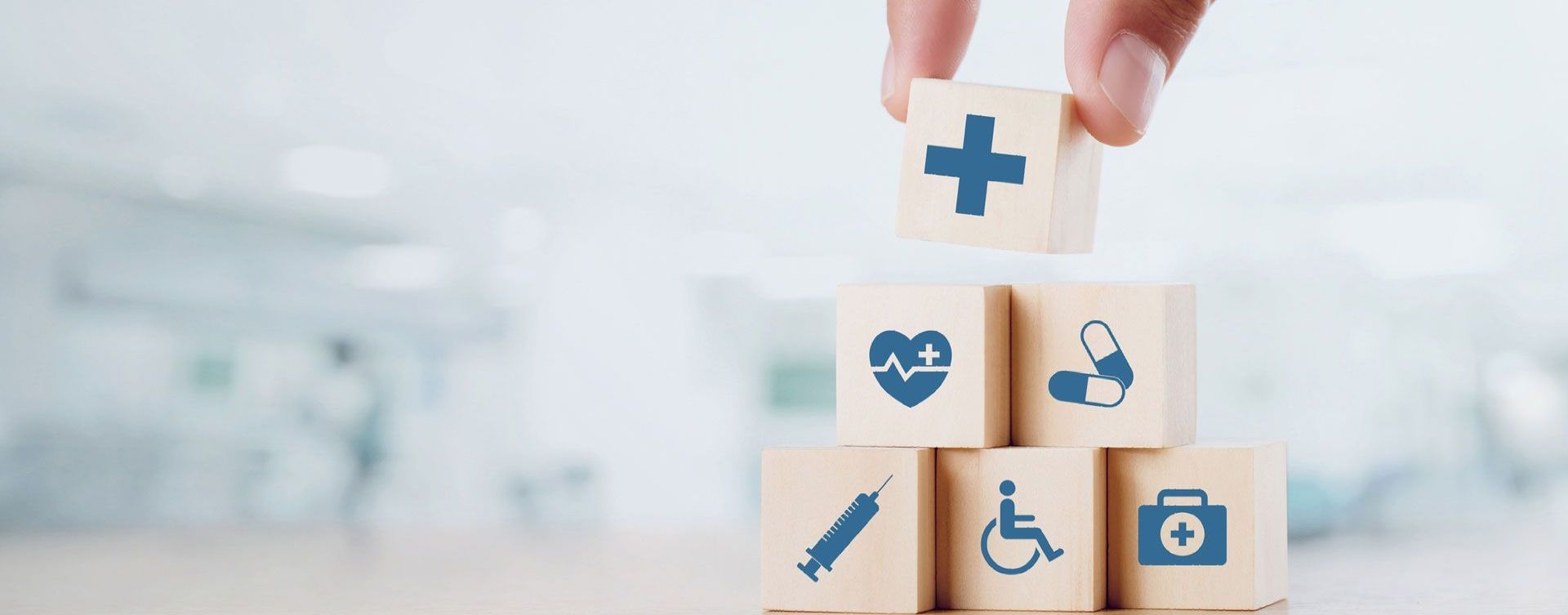 a person is stacking wooden blocks with medical icons on them