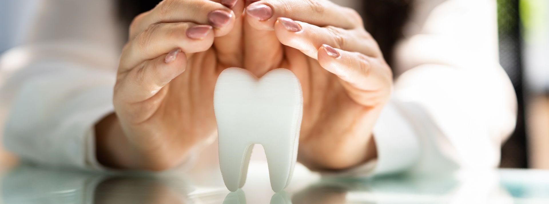 a woman is holding a tooth in her hands .