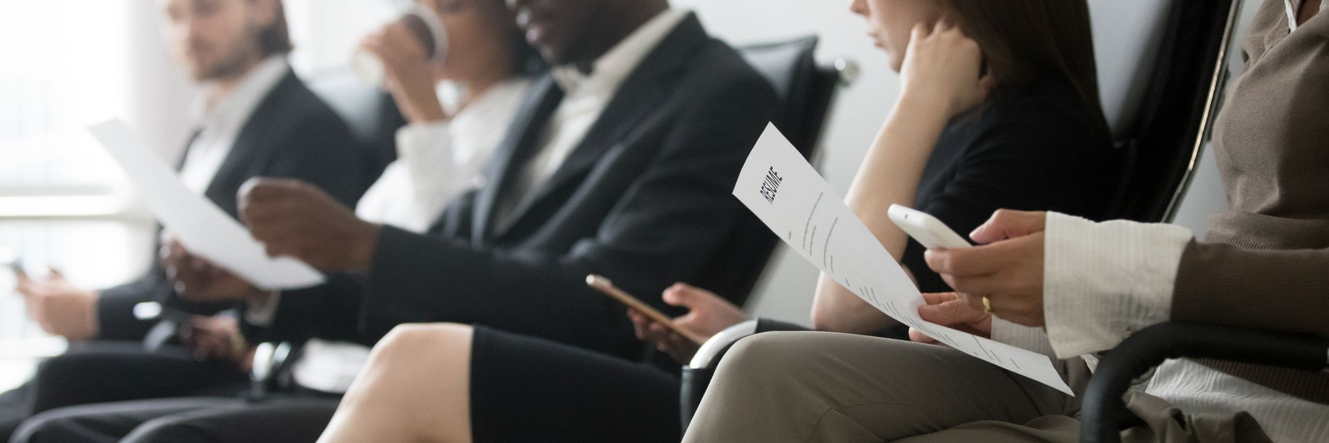 a group of people are sitting in chairs at a job interview .