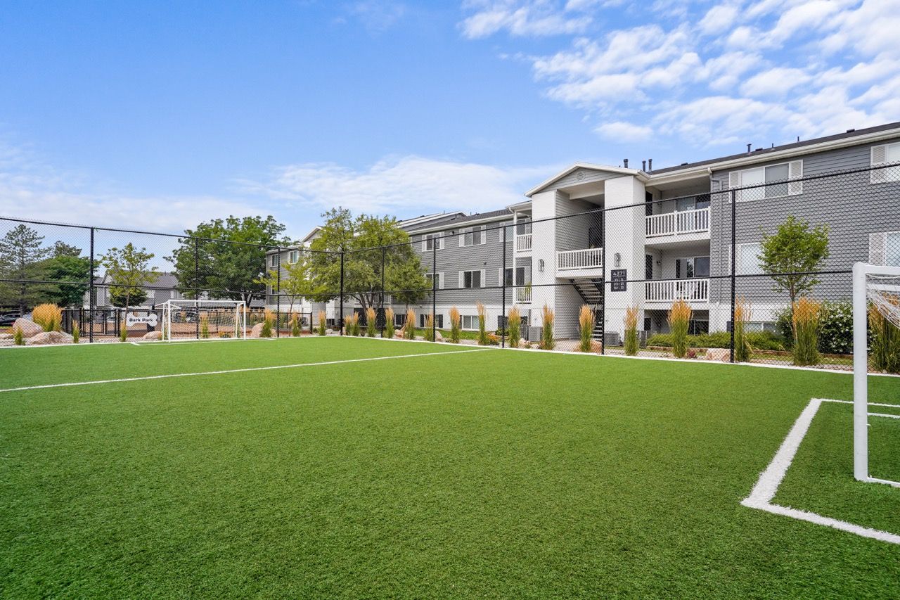Artificial turf soccer field inside an apartment community, with goals and surrounding buildings. Tour Turnberry Apartments and discover convenient apartments near Downtown Salt Lake City, UT, in a welcoming neighborhood.
