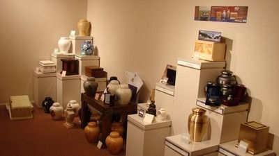 Funeral home display of urns in various shapes, sizes, and colors.