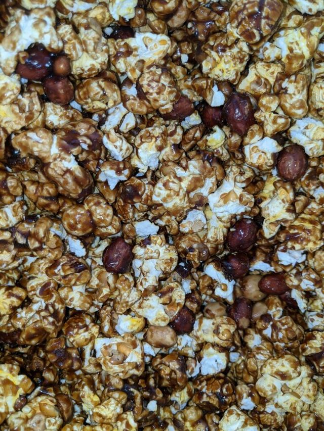 A close up of a pile of popcorn and peanuts.