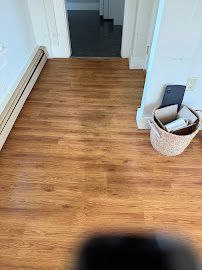 Wood-floored hallway with a wicker basket and doorway at the end