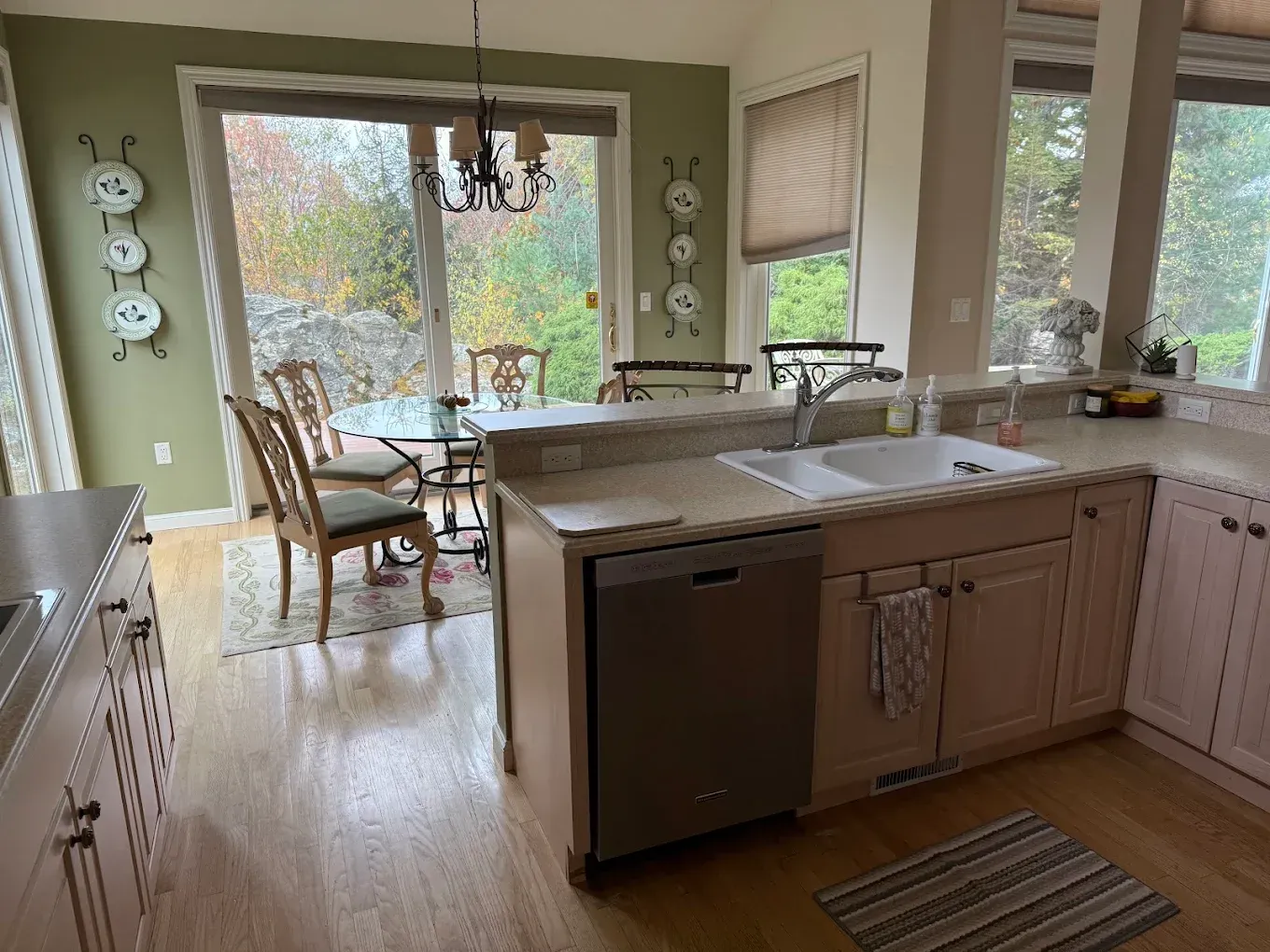 Bright kitchen with island opening to a dining area and large windows overlooking a lake