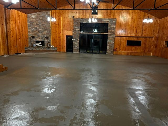 A large room with wood paneling and a concrete floor.