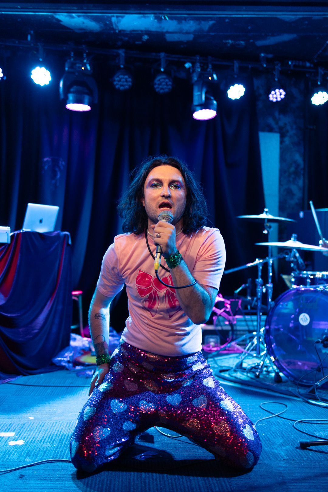 A man is singing into a microphone on a stage.