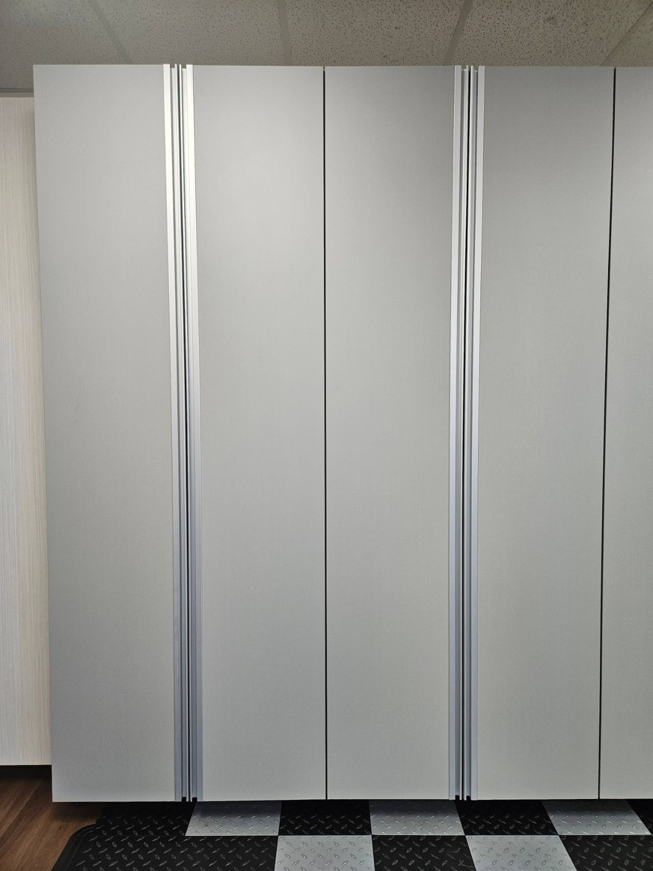 A white cabinet with a checkered floor in the background