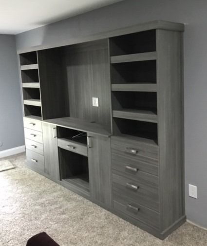 A living room with a lot of shelves and drawers.