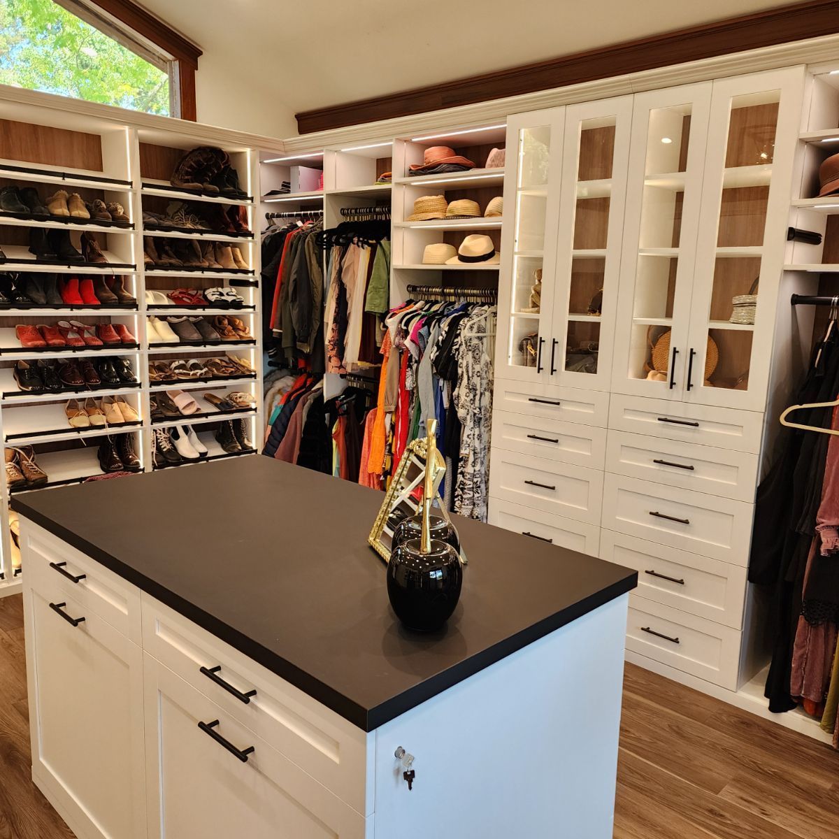 A walk in closet with a large island in the middle