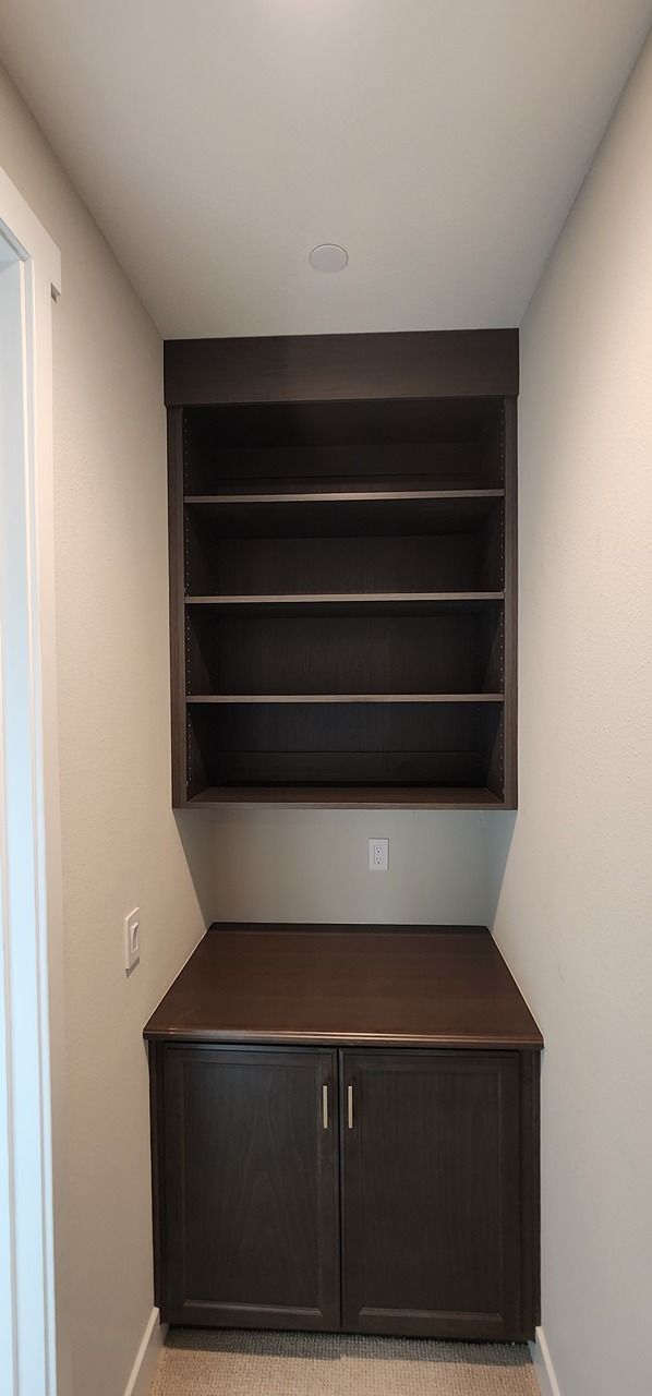 A small room with a desk and shelves in it.
