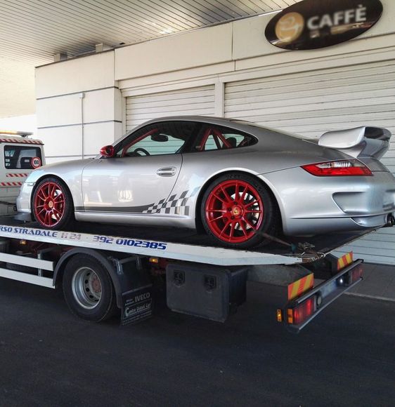 Un'auto sportiva argentata è parcheggiata sopra un carro attrezzi