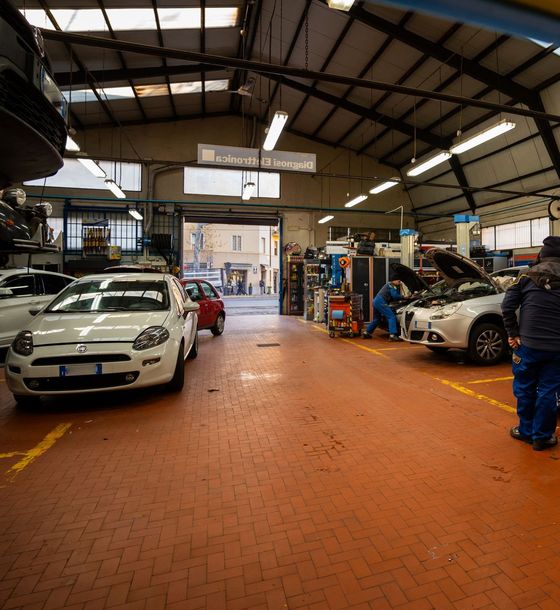 Un uomo è in piedi in un garage con delle auto parcheggiate