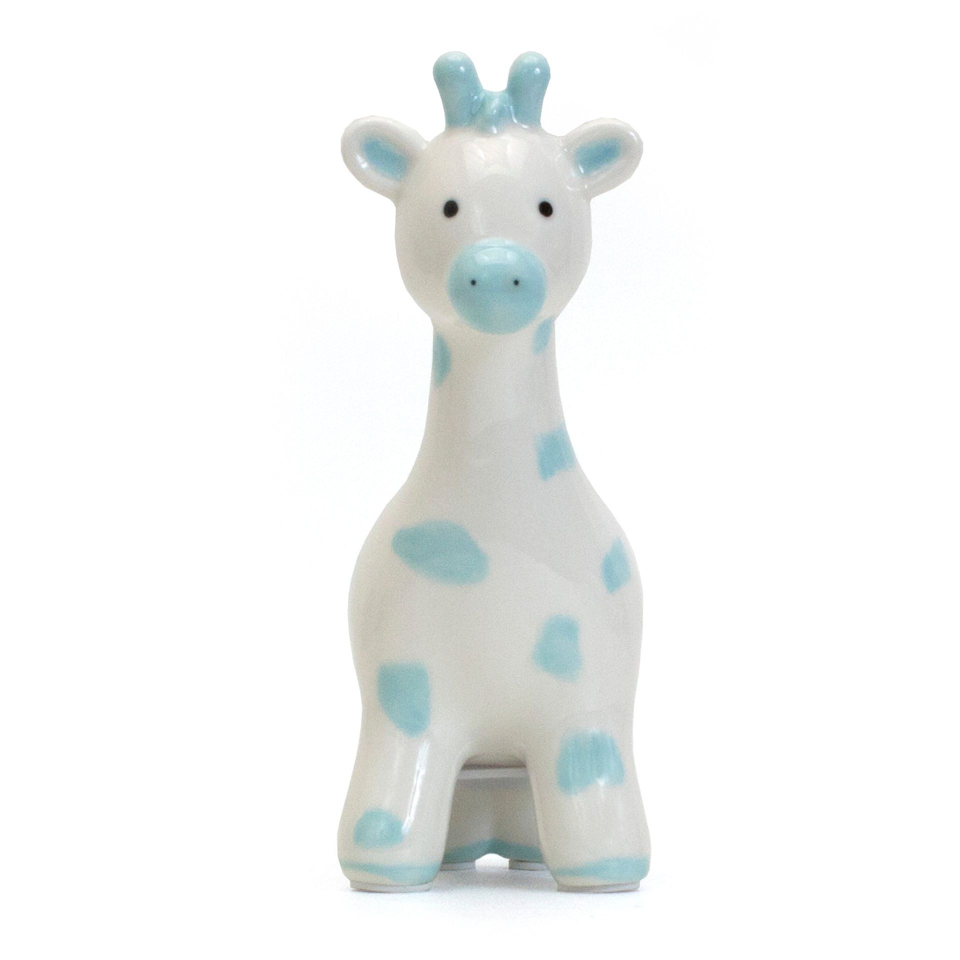 White giraffe figurine with light blue spots and horns on a plain background