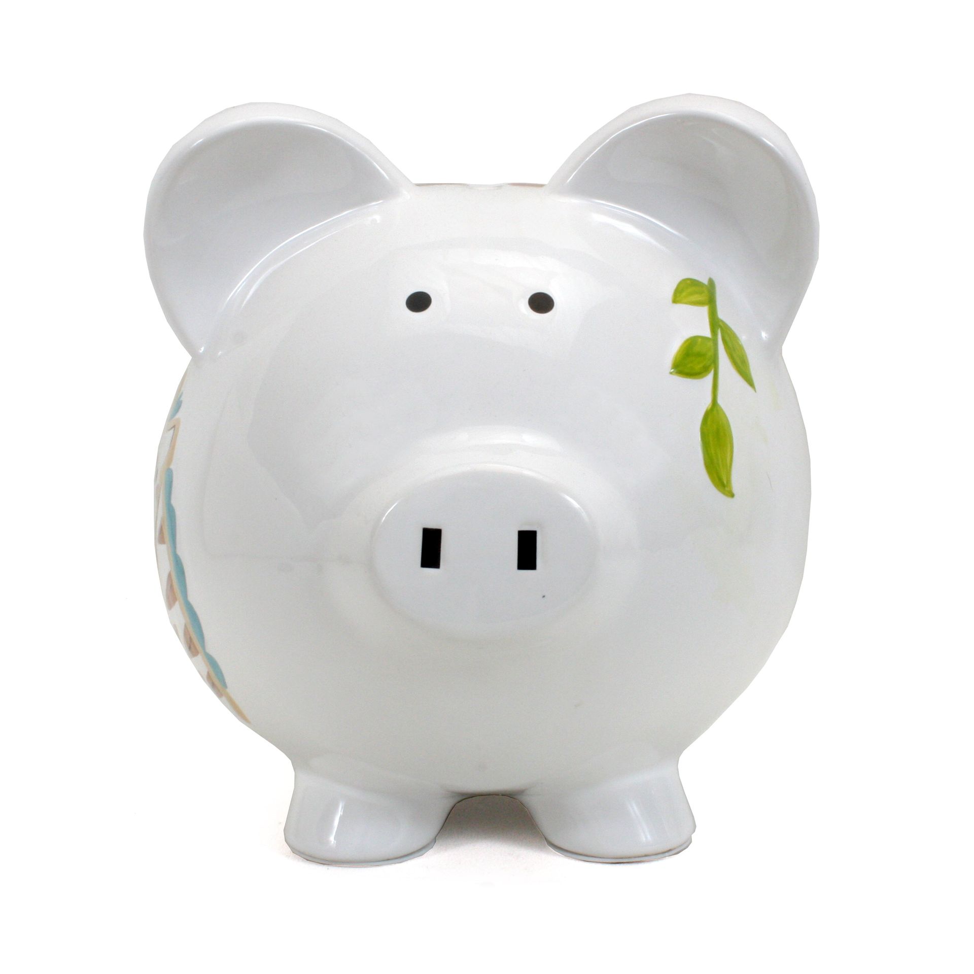 White ceramic piggy bank with a green leaf design on its cheek and black eyes.