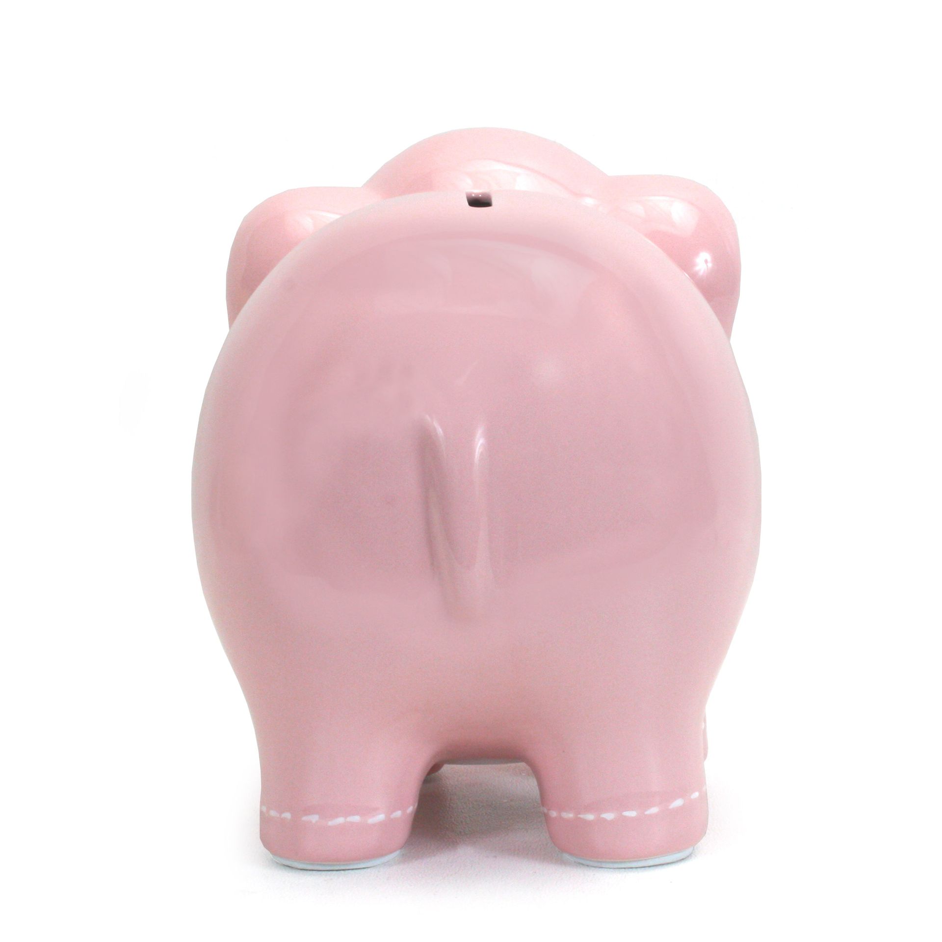 Pink ceramic piggy bank viewed from the back on a white background