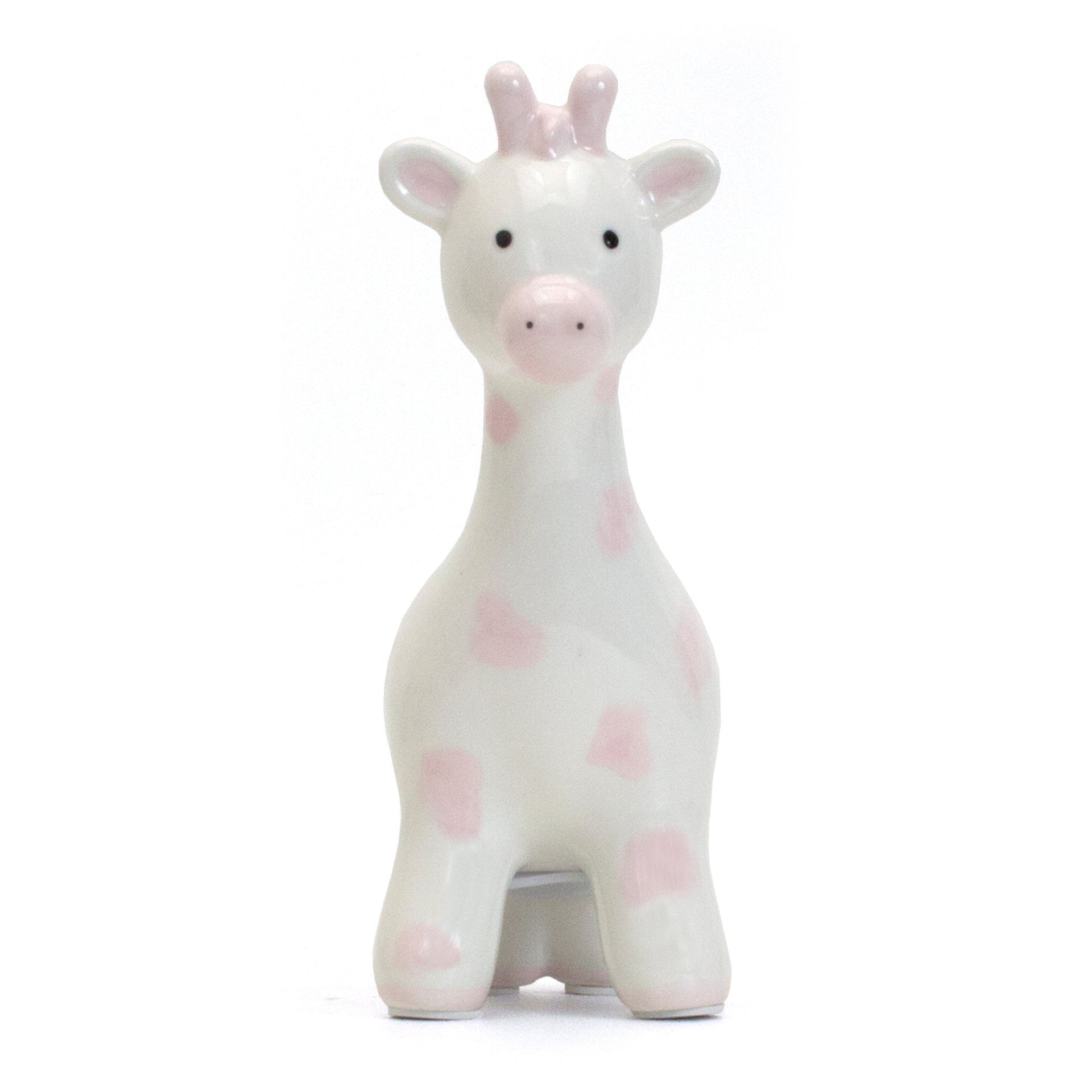 White giraffe figurine with pink spots on a plain background