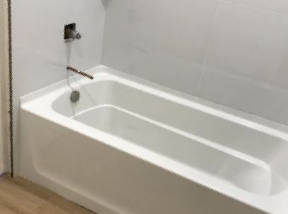 White bathtub with tiled wall, shower faucet, and handheld shower head in a bathroom.