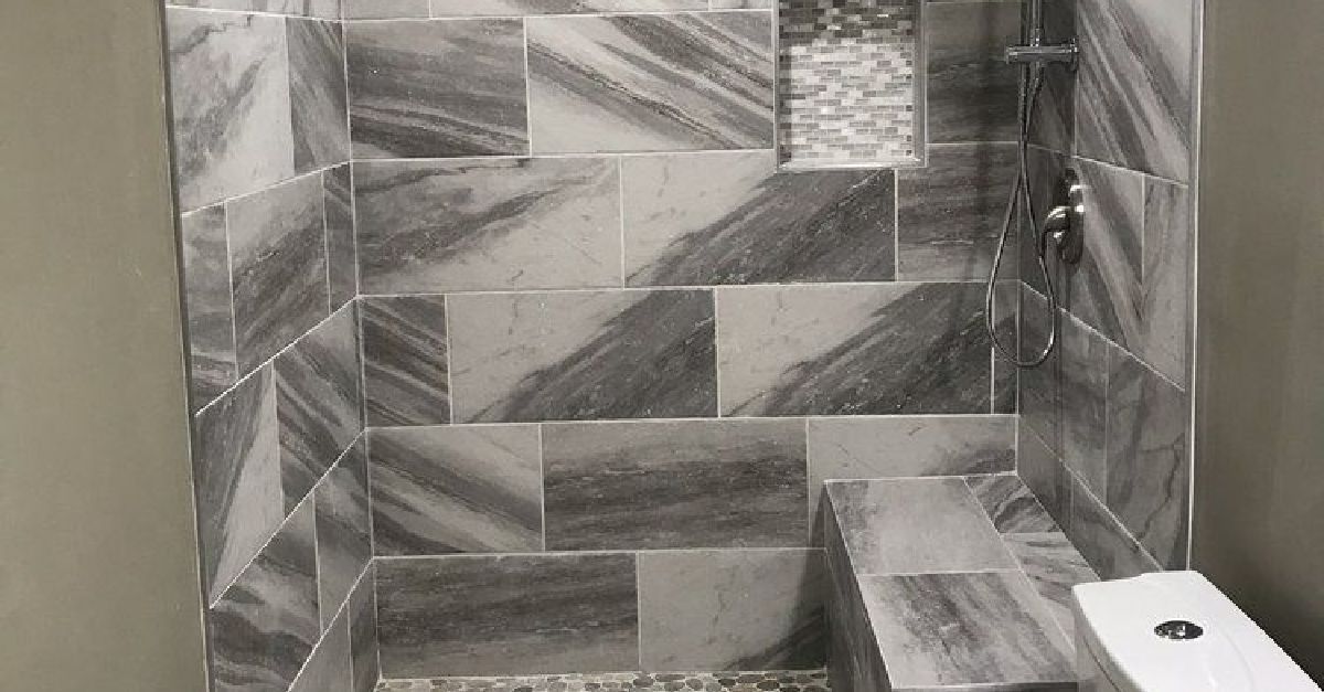 A photo of a bathroom with a tiled shower and a toilet.