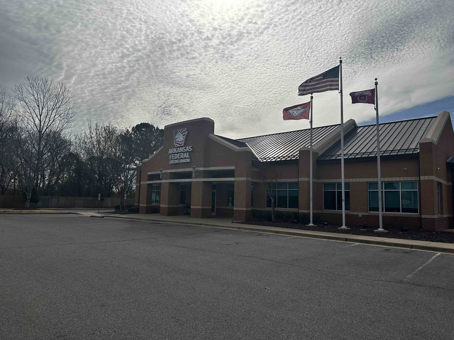 a brick building with three flags flying in front of it .